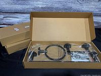 Open box showing brown metal towel ring and hardware