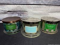 Three HomeWorx candles front view showing labels and lids