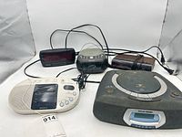 All five alarm clocks arranged together showing fronts and cables