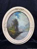 Full view of framed oval landscape artwork