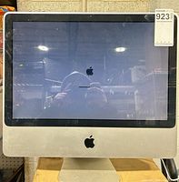 Front view of Apple iMac powering on, Apple logo and progress bar visible on screen