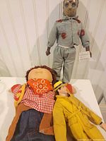 Group shot of three dolls showing full bodies and outfits