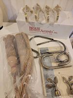 Overview of assorted tiebacks including brass, rope, nickel and leaf styles