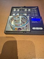 Full set on digital scale showing bracelet, ring, and earrings with weight display