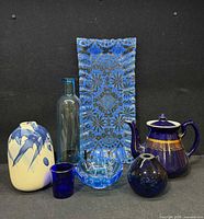 Group shot of all seven blue glass and ceramic items