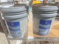 Two gray 5-gallon Sherwin-Williams PVA Drywall Primer & Sealer buckets on shelf