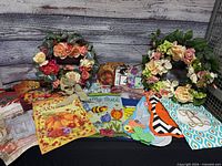 All items displayed on table: two wreaths, multiple garden flags, mailbox numbers