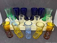 All seventeen colored glass boot shot glasses grouped by color