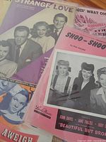 Group of vintage sheet music showing Shoo-Shoo Baby, Strange Love, Anchors Aweigh, and Doin’ What Comes Naturally covers