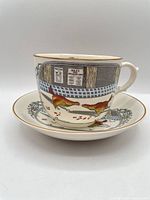 Cup on saucer showing game bird design and gilt rim