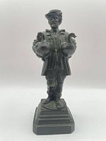 Front view of bronze Gooseman sculpture on stepped base