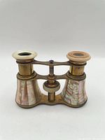 Front view of brass opera glasses showing mother-of-pearl barrels