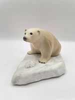 Front view of resin polar bear on white marble base with quartz accent