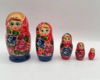 Front view of all five nested dolls lined up by size