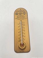 Full view of gold metal advertising thermometer