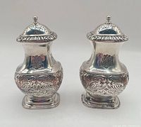 Front view of both silver plate shakers with lids on