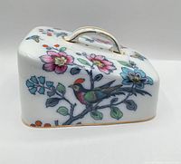 Front angled view showing floral, bird motif and handle