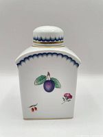 Front of tea caddy showing plum motif, blue scalloped border and lid in place