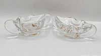 pair of clear freeform crystal ashtrays viewed from front/side