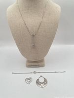 Full lot showing necklace on bust, bracelet, double-heart pendant and hammered pendant