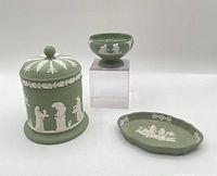 Three Wedgwood sage jasperware pieces: lidded jar, footed open salt on stand, oval tray