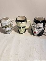 Front view of all three monster mugs