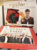 Sealed Harry Potter puzzle box stacked on sealed Downton Abbey board game box