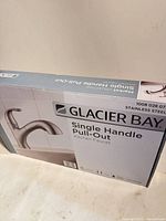 Front of retail box showing Glacier Bay single-handle pull-out kitchen faucet