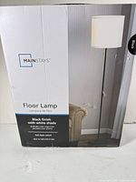 Factory-sealed box front showing Mainstays Floor Lamp, product image, branding and specs