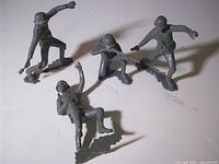 Four grey plastic Marx German soldier figures in various poses