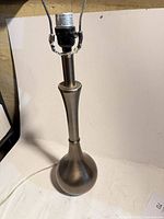 Full view of brushed metal lamp showing socket and cord