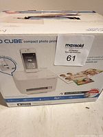 Front of retail box showing VuPoint Photo Cube printer with smartphone docked