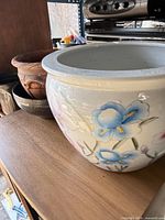 Large porcelain planter with floral design on shelf