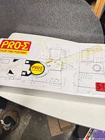 Box lid showing PRO-Σ Drafting Machine branding and technical drawings
