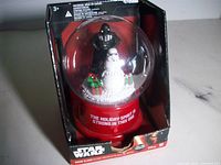 Front view of boxed Star Wars snow globe showing figures and packaging