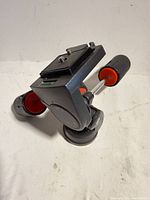 Overall view of tripod head showing quick-release plate, bubble level and handles