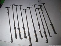 Twelve chrome tension rods and claws laid out
