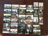 All 32 postcards laid out front side showing building and scenic images