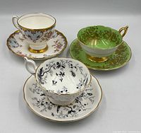 Group view of all three Coalport teacup and saucer sets