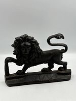 Front view of cast iron lion doorstop on plinth base