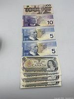 Stack of $100, $10, two $5 and five of the fifteen $1 notes