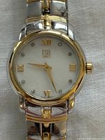 Close front view showing dial, bezel, diamonds, two-tone case