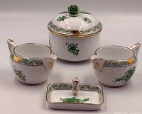 Front view of porcelain set showing jar, two creamers, tray