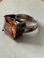 Profile view showing square orange quartz and accent stones on shank