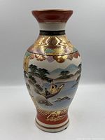 Front view of signed Kutani porcelain vase showing hand-painted landscape and gilt decoration