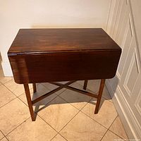 Front view of closed table showing mahogany finish and tapered legs