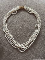 Full view of multi-strand freshwater rice pearl necklace arranged in oval