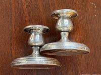 Pair of Birks sterling silver candlestick holders on wooden surface