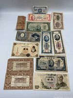 Fronts of 13 banknotes laid out together