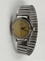 Front angled view showing entire watch with stainless stretch band attached